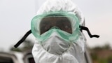 Liberia -- a Liberian nurse wearing protective clothing during the removal and burial of an Ebola victim in the Virginia community on the outskirts of Monrovia, 06 August 2014. 