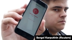 Александр Литреев и телефон с запущенным приложением "Красная кнопка" 