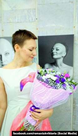 Вікторія Романюк на виставці «Без рожевих окулярів» поруч зі своїм чорно-білим фотопортретом