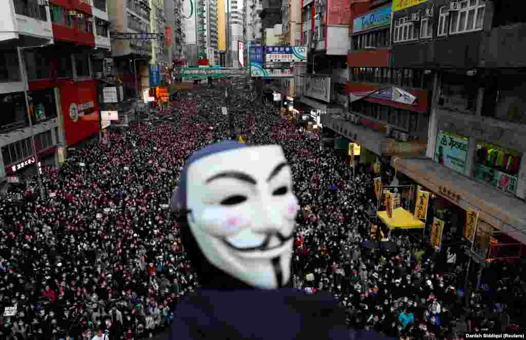 A protester wearing a Guy Fawkes mask marches in a massive protest in Hong Kong on December 8, 2019, against the perceived erosion of democracy there.