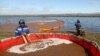 Workers fill a tank for collecting oil-water mixture from the water surface at the site of the spill into the Ambarnaya River outside Norilsk on June 7.
