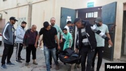 Palestinienii cară cadavrul unuia din voluntarii organizației WCK uciși luni, la spitalul din Deir Al-Balah (Gaza).