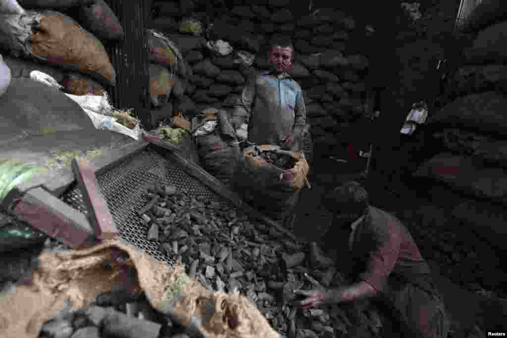 Men sort coal at a wholesale shop to sell in the market in Rawalpindi, Pakistan. (Reuters/Faisal Mahmood)