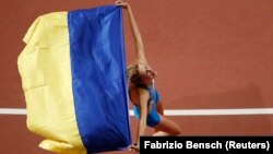 Ярослава Магучіх з прапором україни на чемпіонаті світу з легкої атлетики, Доха, Катар, 30 вересня 2019 року