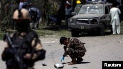 Security forces inspect the site of the explosion in Kabul on June 18 that was thought to have targeted ethnic Hazara lawmaker Mohammad Mohaqiq, Afghanistan’s senior Shi'ite Muslim cleric.