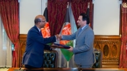 ادریس زمان سرپرست وزارت خارجۀ افغانستان و وینی کمار سفیر هند در کابل در حال مبادله موافقت‌نامه