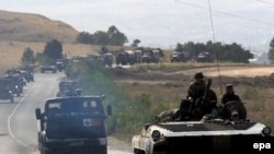 A convoy of armored personnel carriers and other military vehicles on a road leading out of the Georgian town of Gori in the direction of Tbilisi during the August 2008 fighting between Georgian and Russian forces