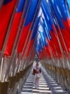 <p>A woman walks amid a display of Russian state flags installed on a square in central Moscow on February 24, the third anniversary of Russia's full-scale invasion of Ukraine. 