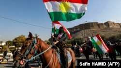 Женщины-бойцы вооруженных отрядов иранских курдов верхом на лошадях во время празднования Дня курдского флага в городе Эрбиль, столице северного автономного Иракского Курдистана. 17 декабря 2024 года