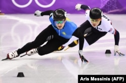 Дж. Р. Целски из США и Денис Никиша из Казахстана (слева) соревнуются в эстафете на 5000 метров среди мужчин в шорт-треке на финальном этапе во время зимних Олимпийских игр 2018 в Пхёнчхане