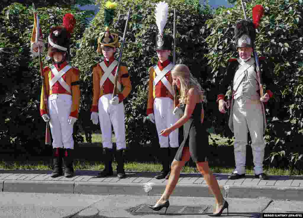A woman passes members of historical clubs dressed in the uniforms of French soldiers during a ceremony marking the repatriation to France of the remains of French General Charles-Etienne Gudin de la Sablonniere, a participant in the French Revolutionary wars and Napoleonic wars, in Moscow on July 13. One of Napoleon Bonaparte&#39;s favorite military commanders died in the Battle of Smolensk during the Russian campaign of 1812. The search for his remains was one of the main goals of a joint archaeological expedition.