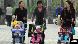 Женщины с детьми на прогулке. Пекин, 5 апреля 2011 года.