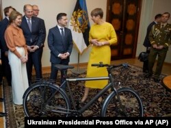 Президент Естонії Керсті Кальюлайд (праворуч) дарує велосипед президенту України Володимиру Зеленському під час їхньої зустрічі у столиці Естонії. Таллінн, 26 листопада 2019 року
