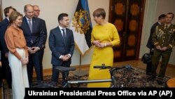 Президент Эстонии Керсти Кальюлайд (справа) дарит велосипед президенту Украины Владимиру Зеленскому