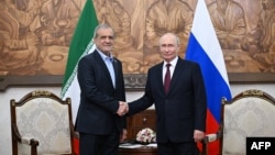 Russian President Vladimir Putin (left) and Iranian President Masud Pezeshkian shake hands during a meeting on the sidelines of the Shanghai Cooperation Organization in Bishkek on September 1.