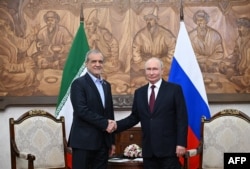 Russian President Vladimir Putin (right) and Iranian President Masud Pezeshkian shake hands during a meeting on the sidelines of the Shanghai Cooperation Organization (SCO) summit in Bishkek.