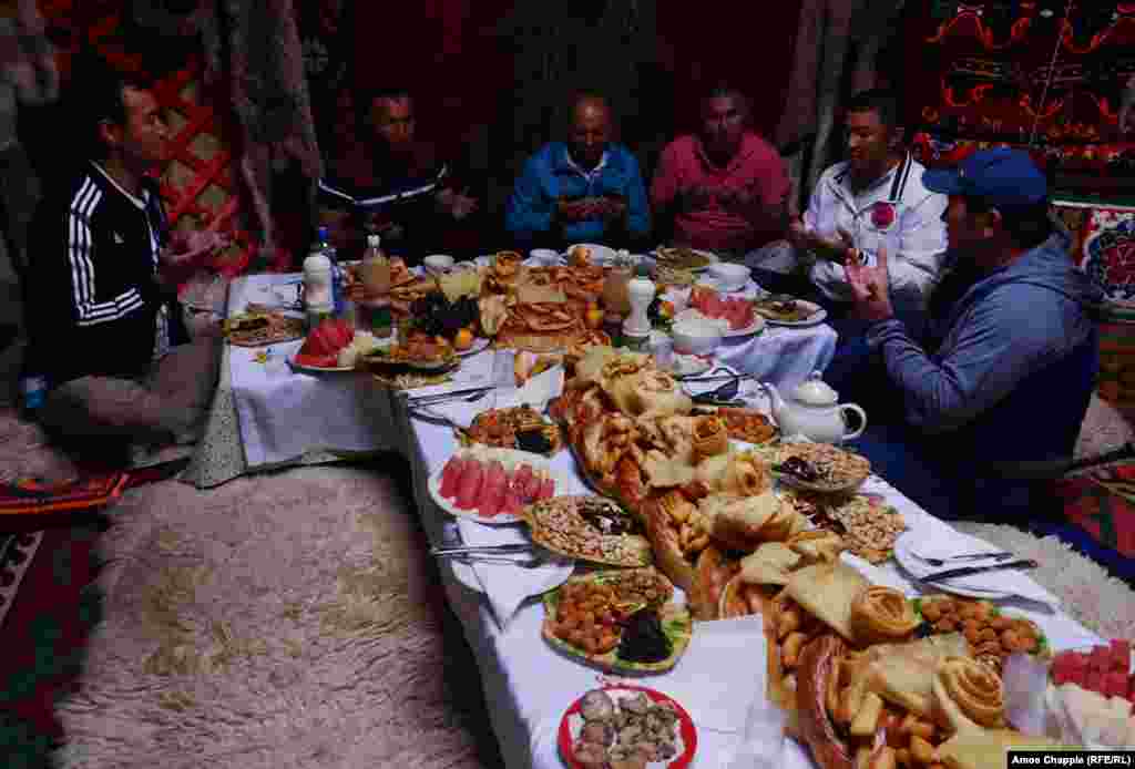 Men pray before eating lunch. Yurt meals are spectacular, though much of the table space is filled with fried bread.&nbsp;