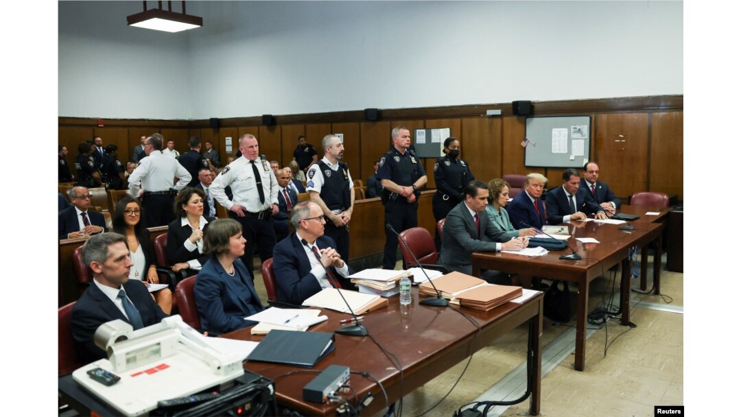 Fostul președinte american Donald Trump, în boxa acuzaților, la un tribunal din Manhattan, New York, flancat de avocați la audierea în care a aflat că procurorul de caz a formulat 34 de capete de acuzare împotriva sa. 4 aprilie 2023, Statele Unite.