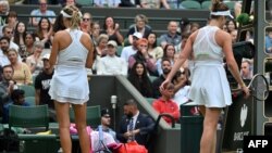 Tenismenele Victoria Azarenka (stânga, Belarus) și Elina Svitolina (dreapta, Ucraina) își întorc spatele una celeilalte la Wimbledon. Svitolina a câștigat partida și nu avea de gând să dea mâna cu oponenta sa; știind acest lucru, Azarenka nici nu s-a oferit. Londra, 9 iulie.