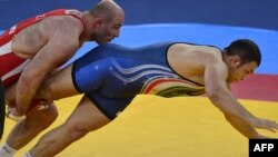 Uzbekistan's Artur Taymazov (left) wrestles Iran's Komeil Ghasemi in their Men's 120kg Freestyle wrestling quarterfinal match at the London 2012 Olympic Games.