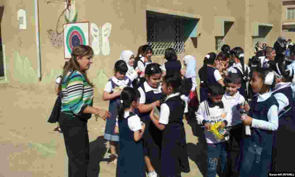 A teacher and her students in the courtyard of their school in Baghdad