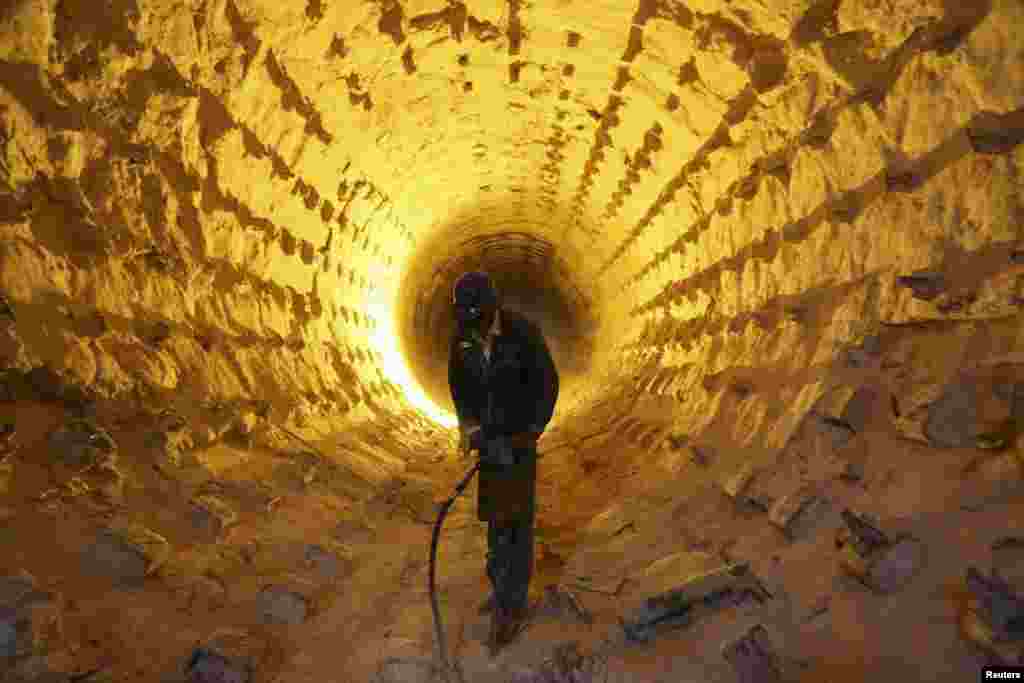 An Iraqi worker operates a drill during a cleanup of the furnace pipes at a cement plant in Najaf, south of Baghdad. (Reuters/Ahmad Mousa)