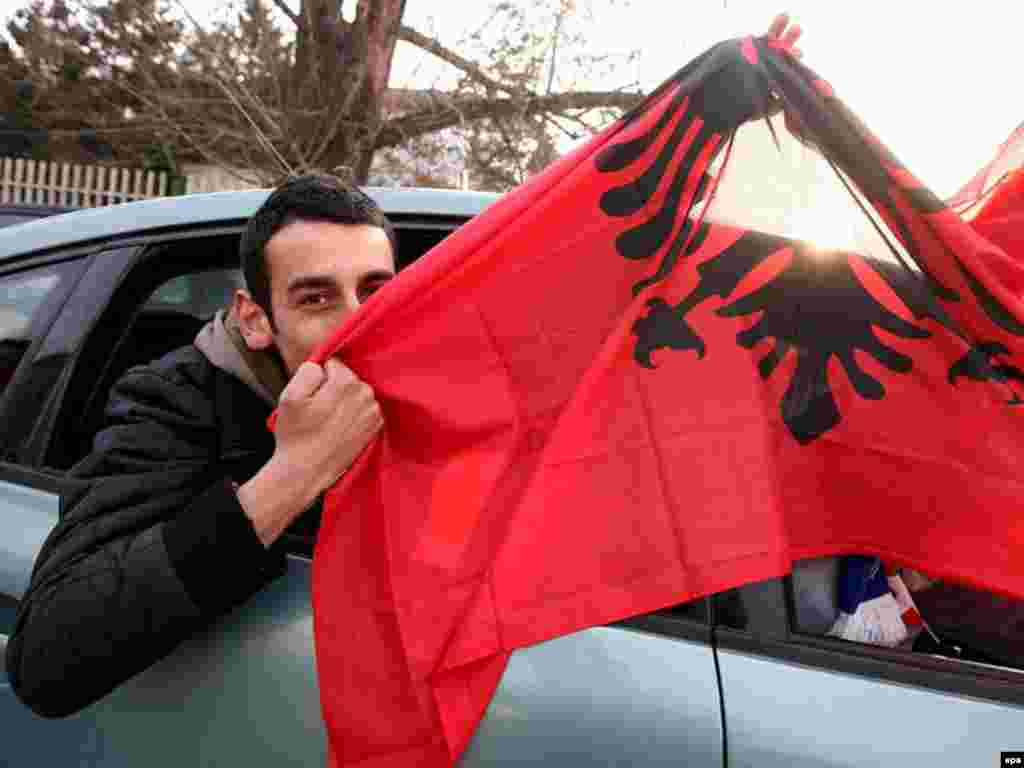 Kremtë në Prishtinë - Caption: epa01256412 An ethnic Albanian kisses the Albanian flag on a car ride through Pristina, Kosovo, 15 February 2008. Leaders of Kosovo's ethnic Albanian majority are expected to proclaim independence from Serbia on Sunday or Monday, the day of a crucial EU foreign ministers meeting that will discuss the issue. Kosovo has been run by the United Nations since mid-1999, after a NATO air assault drove out Serbian forces waging a brutal crackdown on separatist ethnic Albanian guerillas and their civilian supporters. 