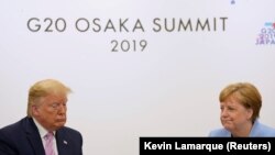 Президент США Дональд Трамп (слева) и канцлер Германии Ангела Меркель на саммите «Большой двадцатки» в Осаке. 28 июня 2019 года.