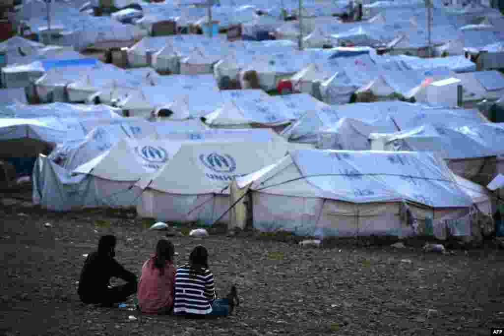 Syrian-Kurdish refugees look out on the Quru Gusik (Kawergosk) refugee camp, 20 kilometers east of Irbil, in the autonomous Kurdish region of northern Iraq. (AFP/Safin Hamed)