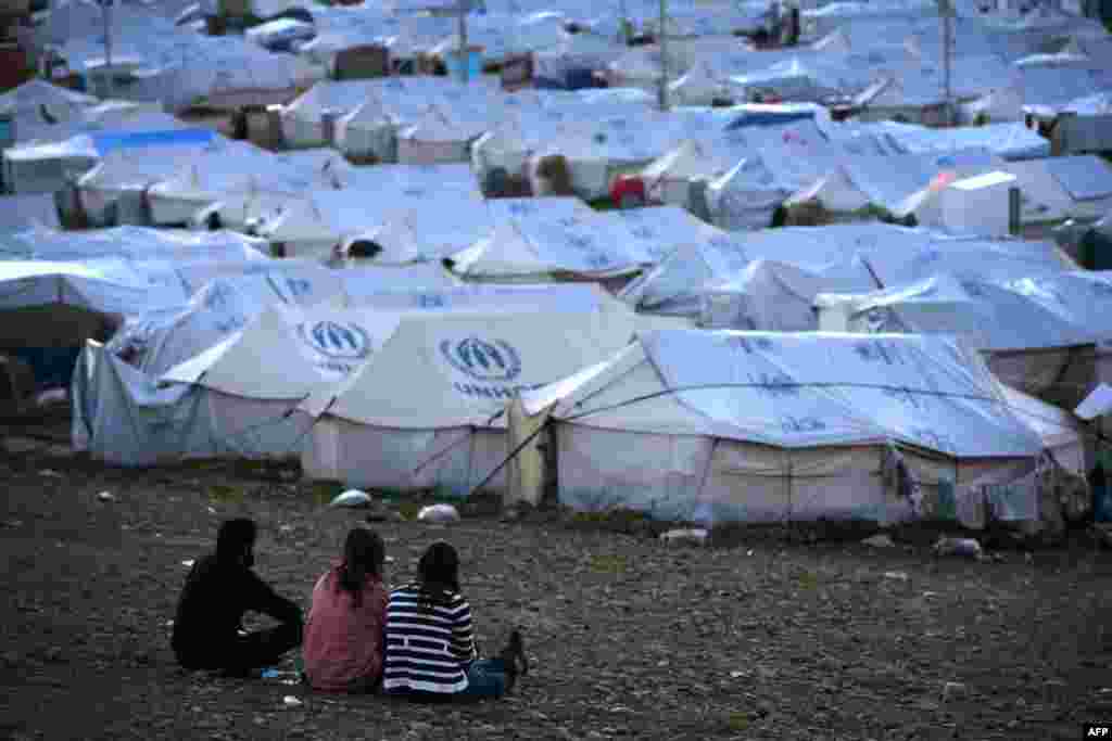 Syrian-Kurdish refugees look out on the Quru Gusik (Kawergosk) refugee camp, 20 kilometers east of Irbil, in the autonomous Kurdish region of northern Iraq. (AFP/Safin Hamed)