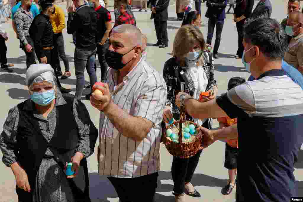 Njerëzit marrin vezët e ngjyrosura jashtë Kishës St. Elya Chaldean në Bagdad, Irak 4 prill 2021.&nbsp;