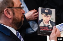 Тогдашний лидер немецких социал-демократов Мартин Шульц просматривает книгу Манфреда Квиринга "Русский мир Путина"