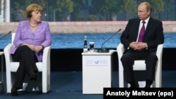 Angela Merkel și Vladimir Putin se contemplează reciproc la ediția din iunie 2013 a SPIEF.