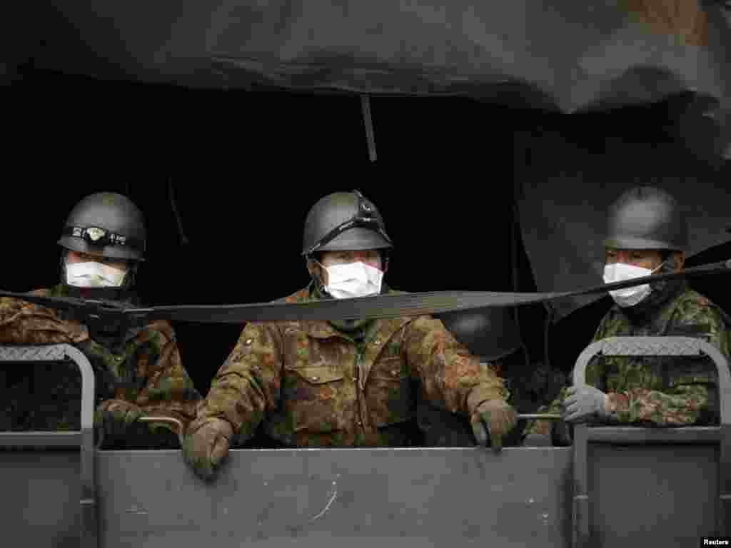 Japan Self-Defense Force officers wearing masks arrive at a residential area in Otsuchi on March 15