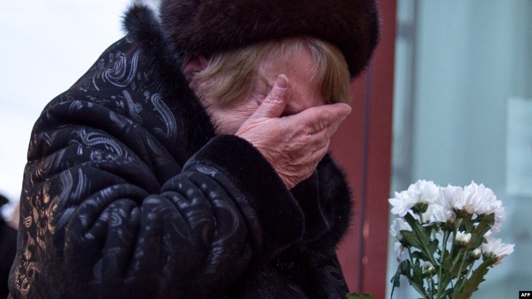 A woman cries as she lays flowers at an impromptu memorial outside a Moscow theater that housed the Aleksandrov Ensemble. Dozens of members of the renowned choir died when the military plane they were traveling on crashed into the Black Sea on December 25.