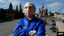 Russian activist Roman Roslovtsev, wearing a rubber mask depicting President Vladimir Putin, poses for a picture in central Moscow on May 12.