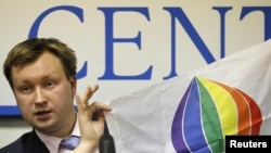 Gay-rights activist Nikolai Alekseyev holding a flag, reading "Moscow Pride '06", during a press conference in Moscow.