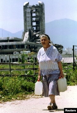 Възрастна жена върви през зона от обсаденото Сараево, набелязана от сръбски снайперисти, напът да си набави вода, 1995 г.
