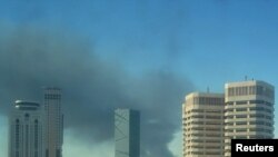 Smoke rises over the western side of Tripoli on October 14.