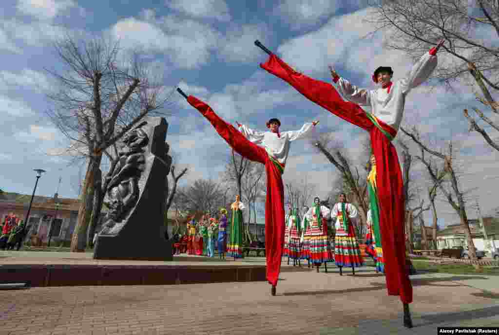 Artists perform near a Soviet-era monument during a celebration of Maslenitsa, also known as Pancake Week, which is a pagan holiday marking the end of winter, in Yevpatoria, Crimea, on March 14. (Reuters/Aleksei Pavlishak)