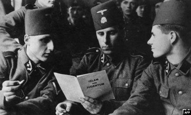 Мусульманські члени «Ваффен СС» читають листівку «Іслам та іудаїзм» у невідомому місці в 1943 році. Навесні 1943 року великий муфтій Єрусалиму Мохаммад Амін аль-Хусейні був завербований нацистами для сприяння в організації та вербуванні босняків, які входили до кількох підрозділів «Ваффен СС» та інших підрозділів із території Югославії. Найбільшою була 13-а дивізія «Хандшар», чисельністю 21 065 осіб, яка проводила операції проти комуністичних партизанів на Балканах із лютого 1944 року. Після Другої світової війни Аль-Хусейні був засуджений Верховним військовим судом Югославії до трьох років позбавлення волі і двох років позбавлення громадянських прав як засуджений воєнний злочинець. Помер у Лівані, в Бейруті, у 1974 році
