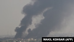 Smoke rises from the site of an attack after a massive explosion the night before near the Green Village in Kabul on September 3.