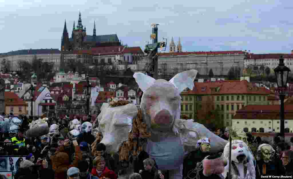 People wearing masks march across the medieval Charles Bridge to commemorate the 27th anniversary of the 1989 Velvet Revolution in Prague on November 17. (Reuters/David Cerny)