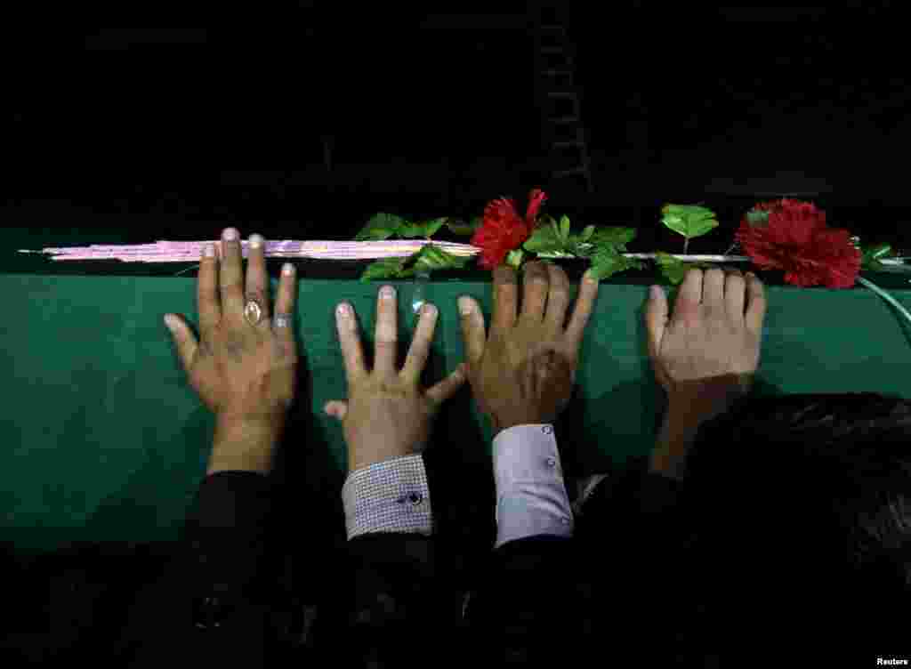 Men carry one of the coffins of the seven slain ethnic Hazaras.