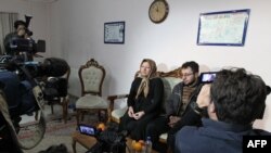 Sakineh Mohammadi Ashtiani, an Iranian woman sentenced by an Iranian judge to death by stoning for adultery, sits next to her son, Sajjad Qaderzadeh, during an interview with journalists from international media in the city of Tabriz.