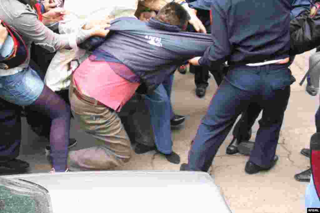 Полиция ұстап әкетпек болған «Алға» партиясының белсендісі Бозжан Құрақбаевқа серіктері ара түсіп, полицейлермен жұлқыласып қалды. Алматы, 1 мамыр, 2010 жыл.
