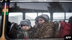 Женщина с ребенком садятся в автобус для эвакуации из Дебальцево, 1 февраля 2015 года