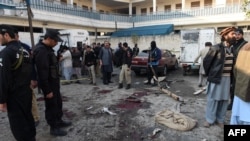 Pakistani security personnel gather evidence at the blast site of a deadly suicide attack by the TTP extremist group in the northern city of Mardan that killed at least 21 people on December 29. 