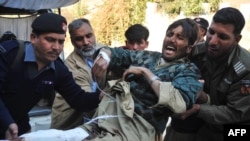 Pakistani rescuers take an injured person from the suicide bombing to the hospital in Peshawar.