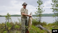 Путин с пойманной щукой на отпуске в Туве, 20 июля 2013 года